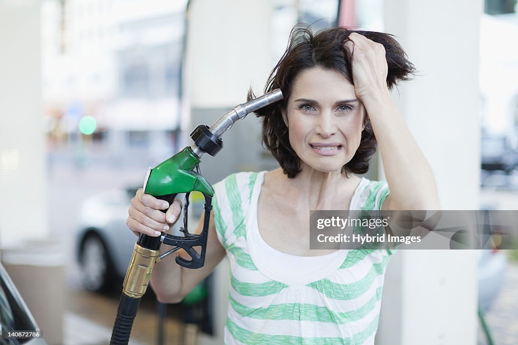 Frustrated woman pumping gas into hair
