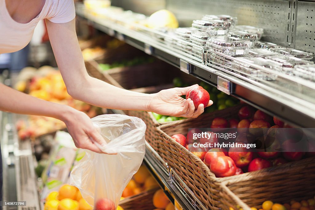 Woman selecting fruit at grocery store