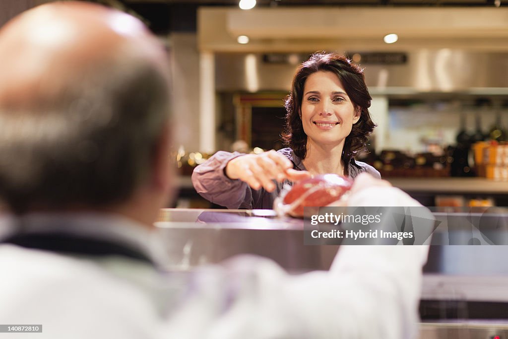 Woman buying meat from butcher