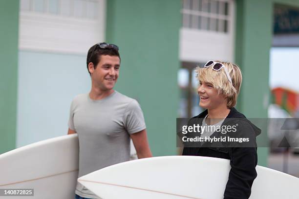 teenage boys carrying surfboards - teen boy barefoot stock pictures, royalty-free photos & images