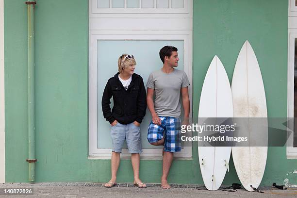 teenage boys standing with surfboards - teen boy barefoot stock pictures, royalty-free photos & images