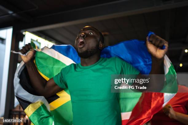 tifoso della squadra sudafricana che guarda la partita e festeggia in un bar - championship round one foto e immagini stock
