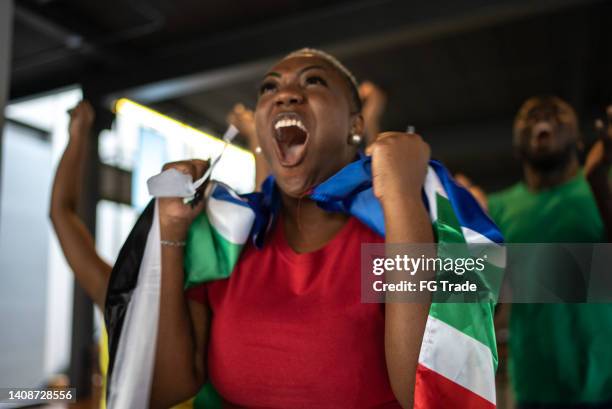 sports fan friends watching game match and celebrating in a bar - south african culture stock pictures, royalty-free photos & images