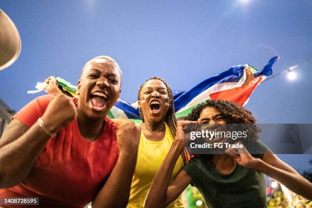 sports fan friends celebrating outdoors - south africa flag stock pictures, royalty-free photos & images