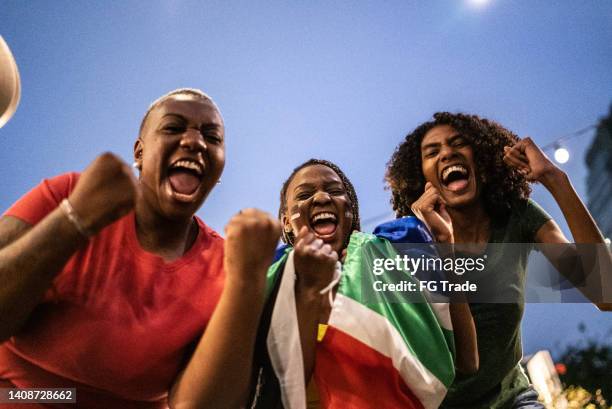 sports fan friends celebrating outdoors - south african culture stock pictures, royalty-free photos & images