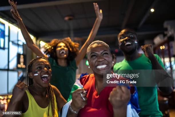 sports fan friends watching game match and celebrating in a bar - mens world championship stock pictures, royalty-free photos & images