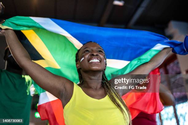 young woman holding south african flag and celebrating - south african culture stock pictures, royalty-free photos & images