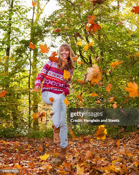 woman playing in fall leaves - throwing leaves stock pictures, royalty-free photos & images