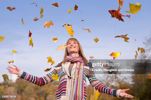 mujer jugando con hojas de otoño - parte de planta fotografías e imágenes de stock