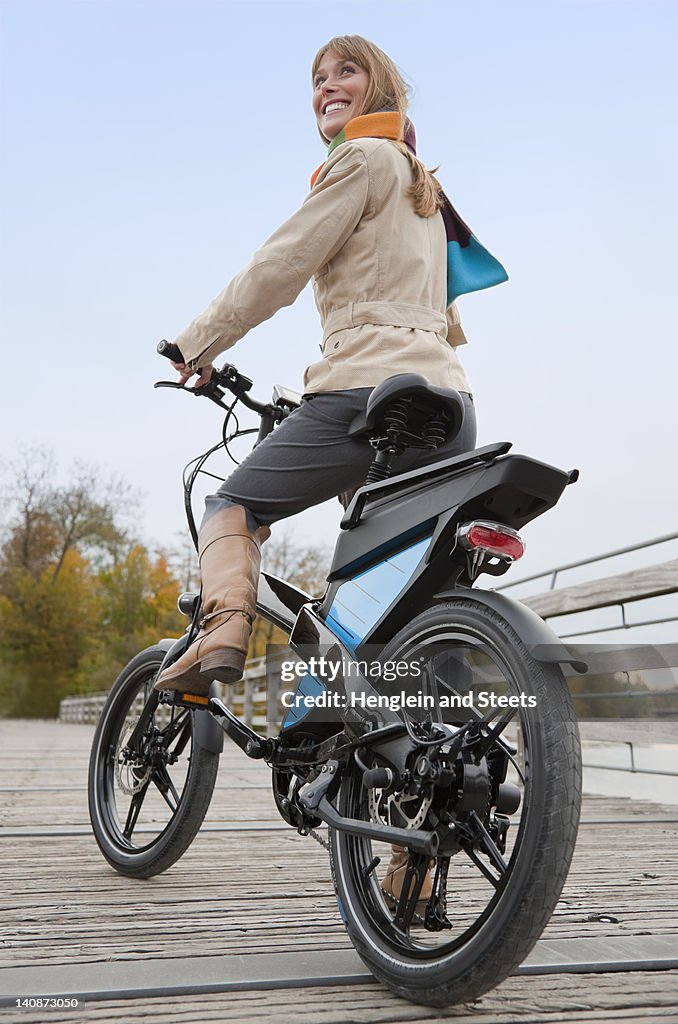Woman riding bike on wooden walkway