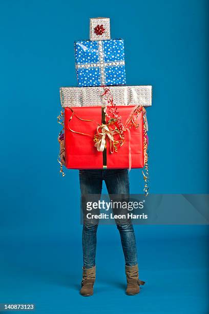 woman carrying wrapped gifts - pile of gifts stock pictures, royalty-free photos & images
