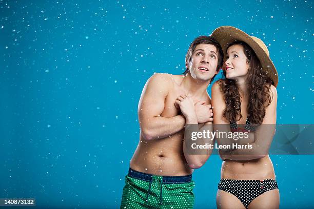 couple in swimsuits shivering in snow - beef stockfoto's en -beelden