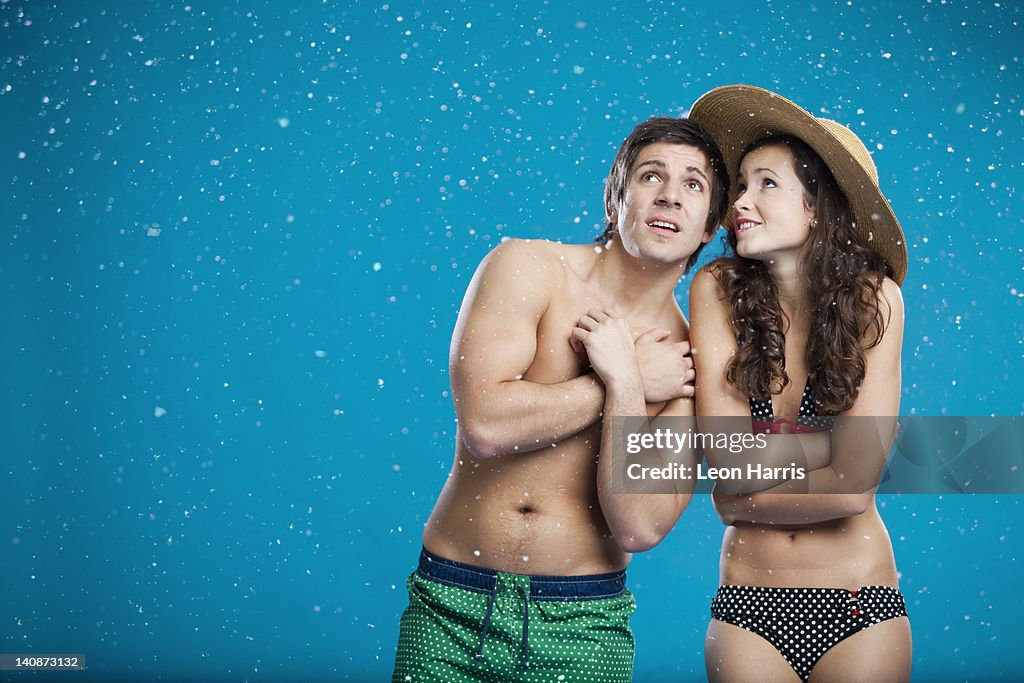 Couple in swimsuits shivering in snow
