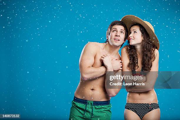 couple in swimsuits shivering in snow - swimwear stock pictures, royalty-free photos & images