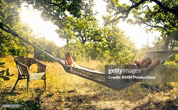 man relaxing in hammock outdoors - garden summer enjoy stock-fotos und bilder