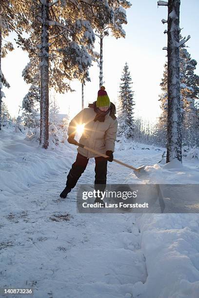 man shoveling snow on rural path - snow shovel stock pictures, royalty-free photos & images