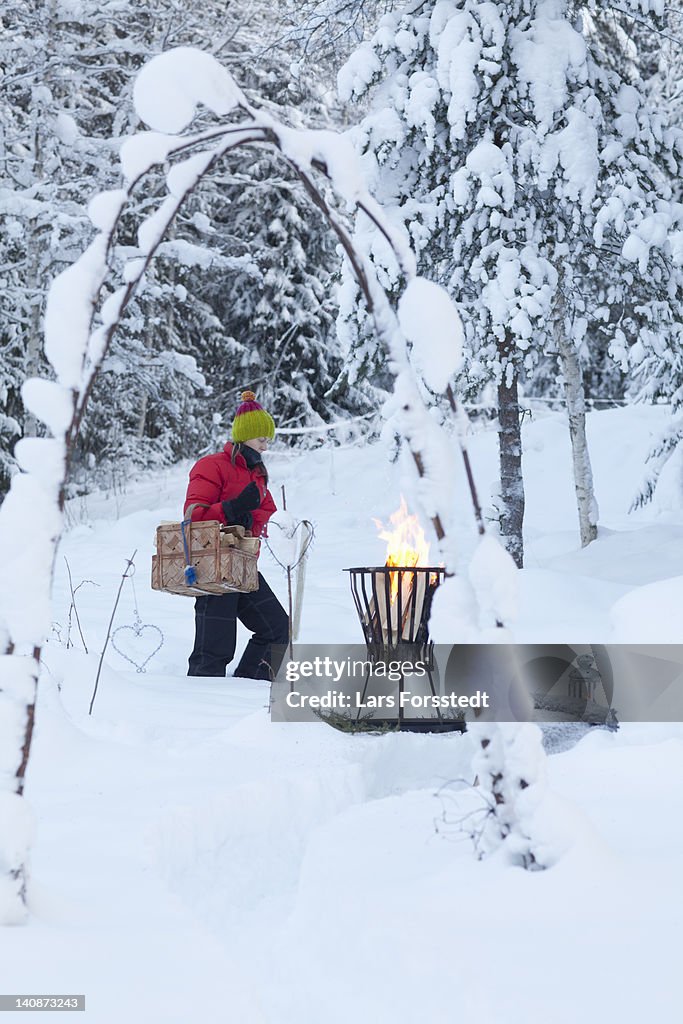 Woman with picnic basket in snowy field