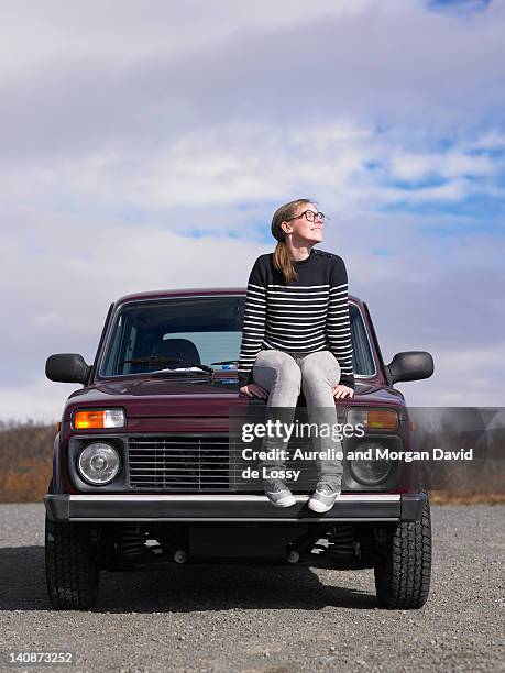 frau sitzt im freien auf dem jeep - motorhaube stock-fotos und bilder