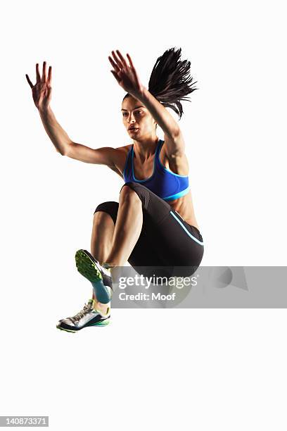 athlete jumping in mid air - verspringen stockfoto's en -beelden
