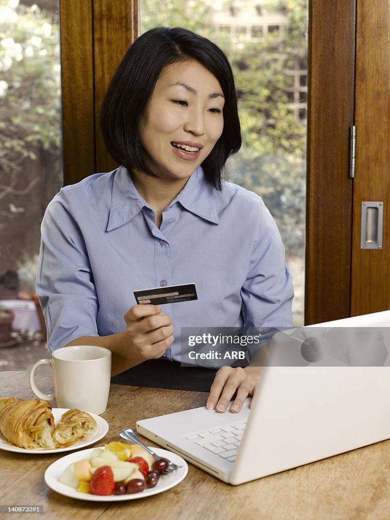 Businesswoman eating and shopping online