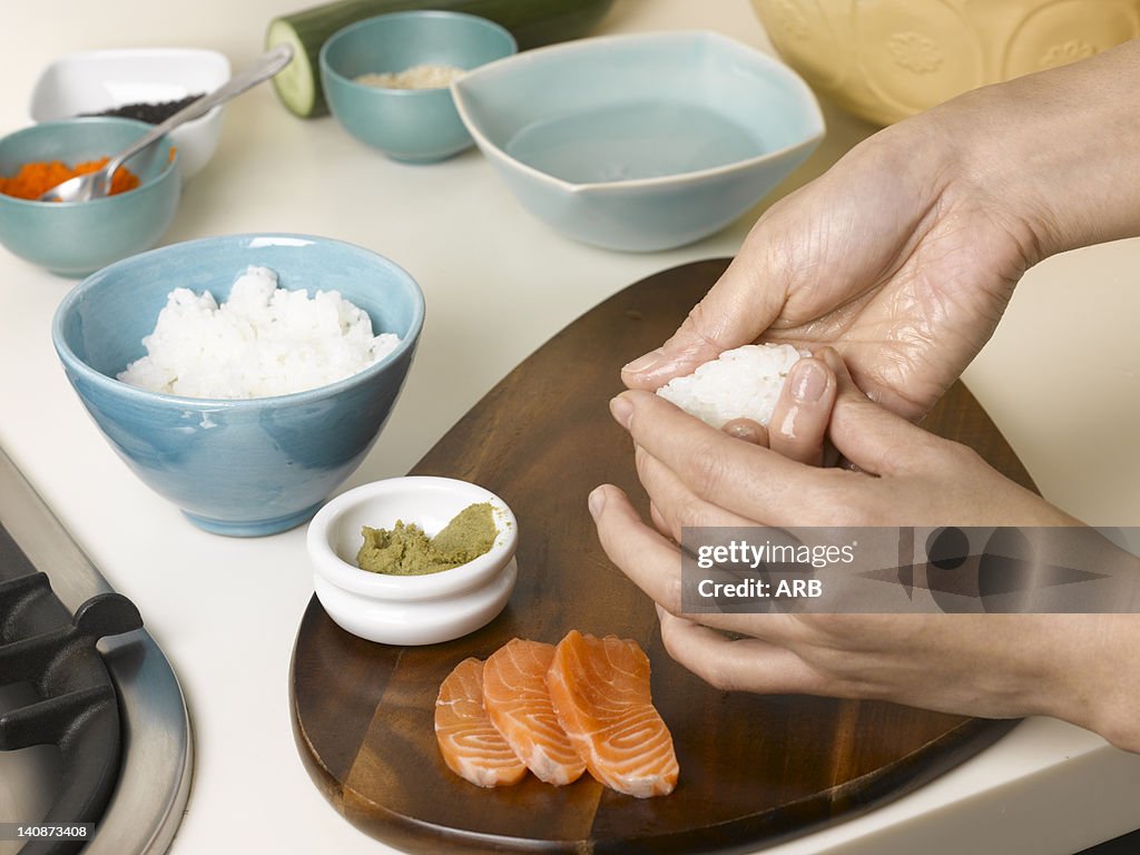 Woman preparing sushi at table