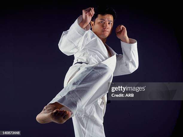 man practicing martial arts - karateka stock-fotos und bilder