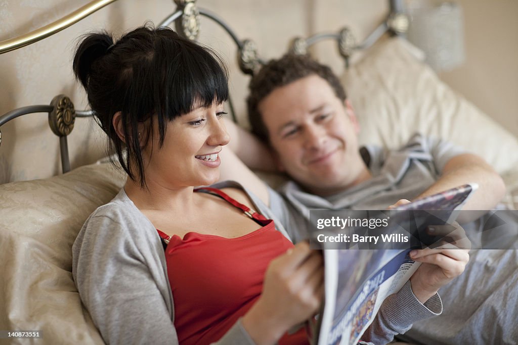 Paar lesen Zeitung im Bett