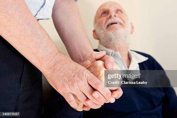 son patting fathers hand - weakness stock pictures, royalty-free photos & images