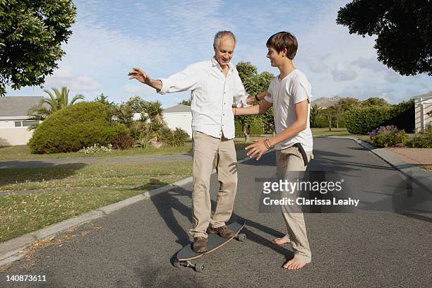 father and son playing with skateboard - teen boy barefoot 個照片及圖片檔