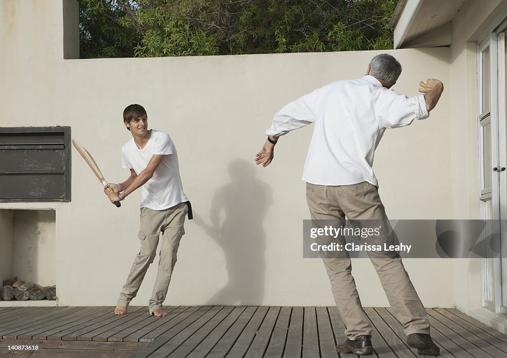 Padre e figlio giocano a cricket sul patio