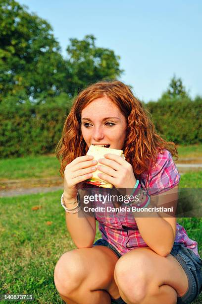 teenage girl eating sandwich in backyard - turin food stock pictures, royalty-free photos & images