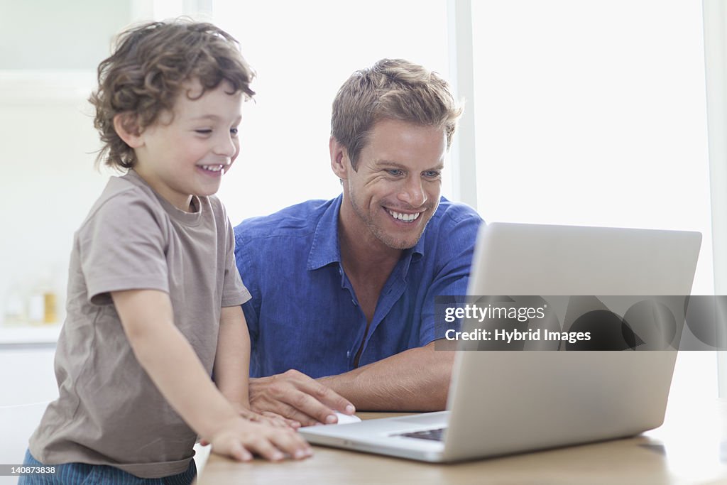 Father and son using laptop together