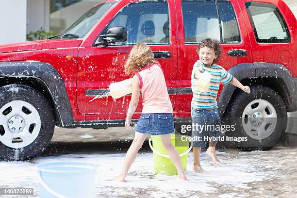 children playing and washing car - car wash stockfoto's en -beelden