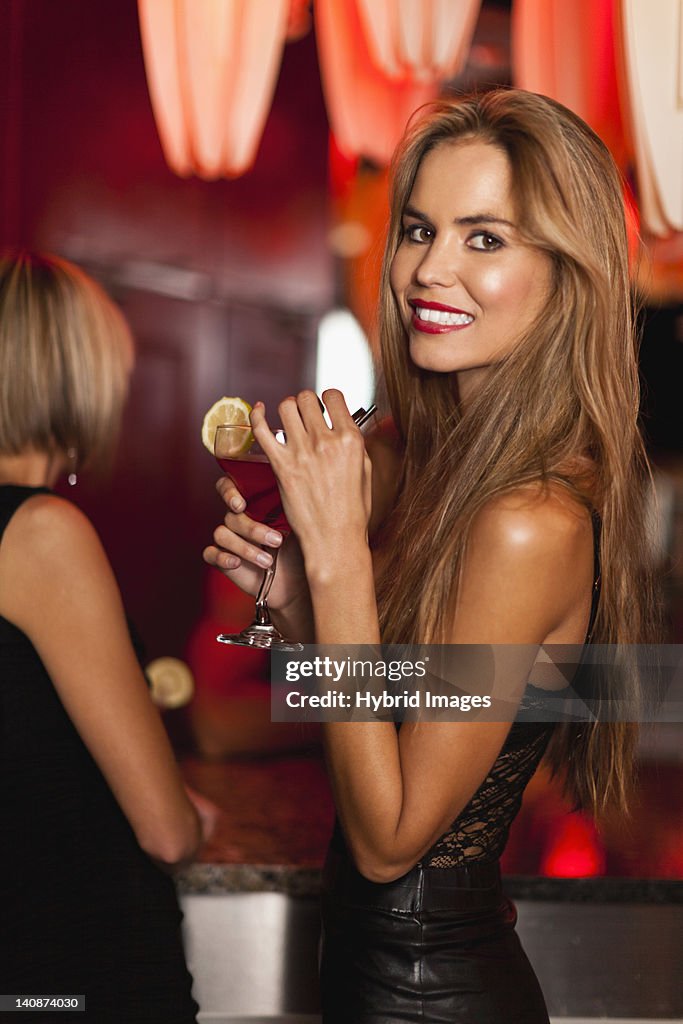 Smiling woman having cocktails in bar