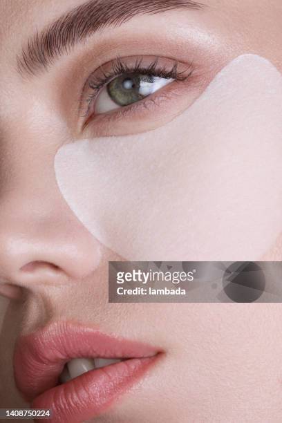 beautiful woman with under-eye patches - medical eye patch stockfoto's en -beelden