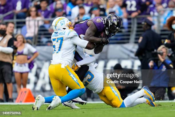 Amen Ogbongbemiga of the Los Angeles Chargers and Chris Harris of the Los Angeles Chargers tackle Latavius Murray of the Baltimore Ravens during an...
