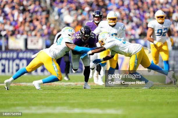 Kyzir White of the Los Angeles Chargers and linebacker Amen Ogbongbemiga tackle Latavius Murray of the Baltimore Ravens during an NFL game at M&T...