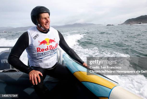 John Hadley, a paddleboard racer from Forestville in Sonoma County, climbs aboard a support boat to hitch a ride to the starting line of the Red Bull...