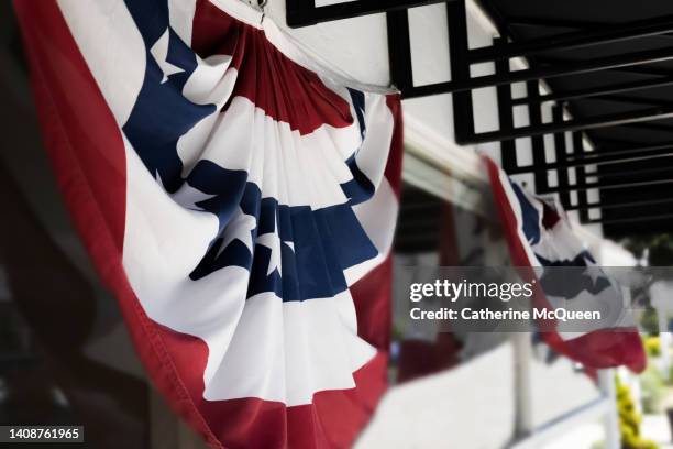 american flag banner on small town retail storefront - american flag small stock pictures, royalty-free photos & images
