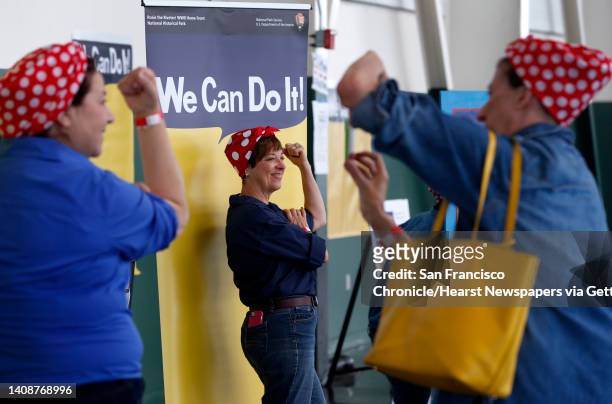 June Burnett has her picture taken with the famous slogan as participants arrive to attempt a new Rosie the Riveter record at the Home Front Festival...