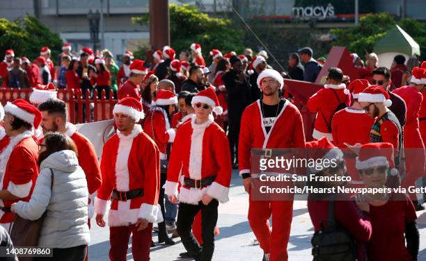 Costumed revelers wander through Union Square for the annual SantaCon gathering in San Francisco, Calif. On Saturday, Dec. 8, 2018. The event was...