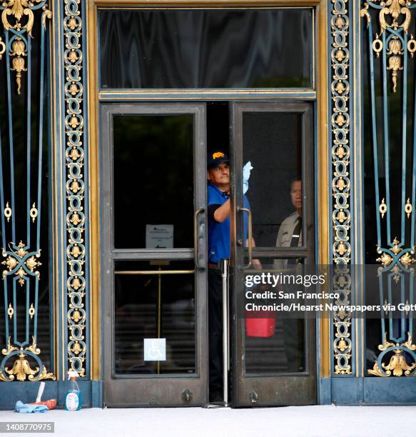 Custodian cleans the front door before London Breed is sworn in as mayor at City Hall in San Francisco, Calif. On Wednesday, July 11, 2018.