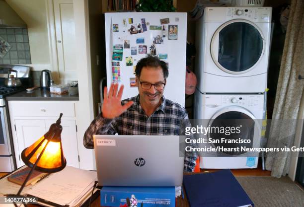 Will Cautero waves to Las Lomas High School students as they log in for an 11th grade English class conducted remotely from his home in Oakland,...