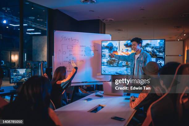 asian chinese esport team coach briefing strategy to team before grand final videogame competition in meeting room with white board and television - league showcase stock pictures, royalty-free photos & images