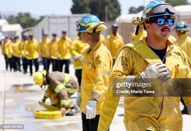 Cadets, who were formerly incarcerated, load fire hoses at the Ventura Training Center during an open house demonstration for media and prospective...