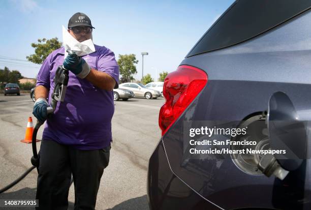 Cesar Guzman prepares to pump gas from his Booster mobile refueling truck into a car parked in a Silicon Valley Bank parking lot in Santa Clara,...