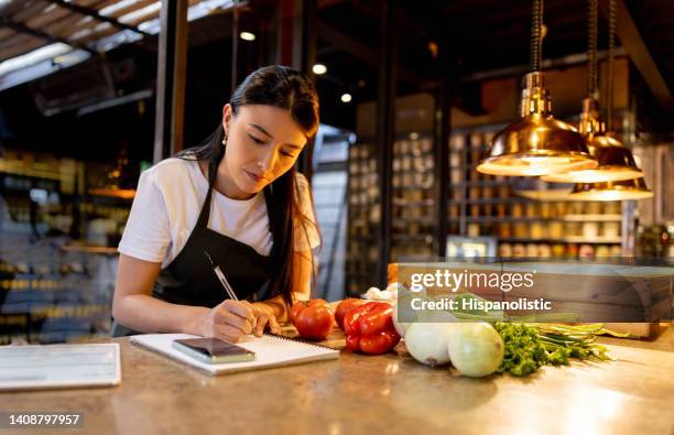 waitress working at a restaurant and writing the menu specials on a notepad - restaurant menu stock pictures, royalty-free photos & images