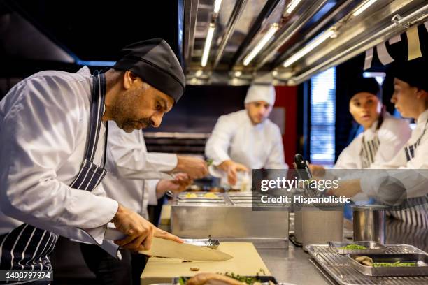 chef working ar a restaurant preparing food and chopping some ingredient - chopping vegetables stock pictures, royalty-free photos & images