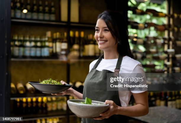 serveuse heureuse servant une cuisine dans un restaurant - tablier photos et images de collection