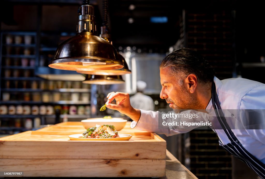 Chef decorando un plato mientras trabaja en la cocina de un restaurante
